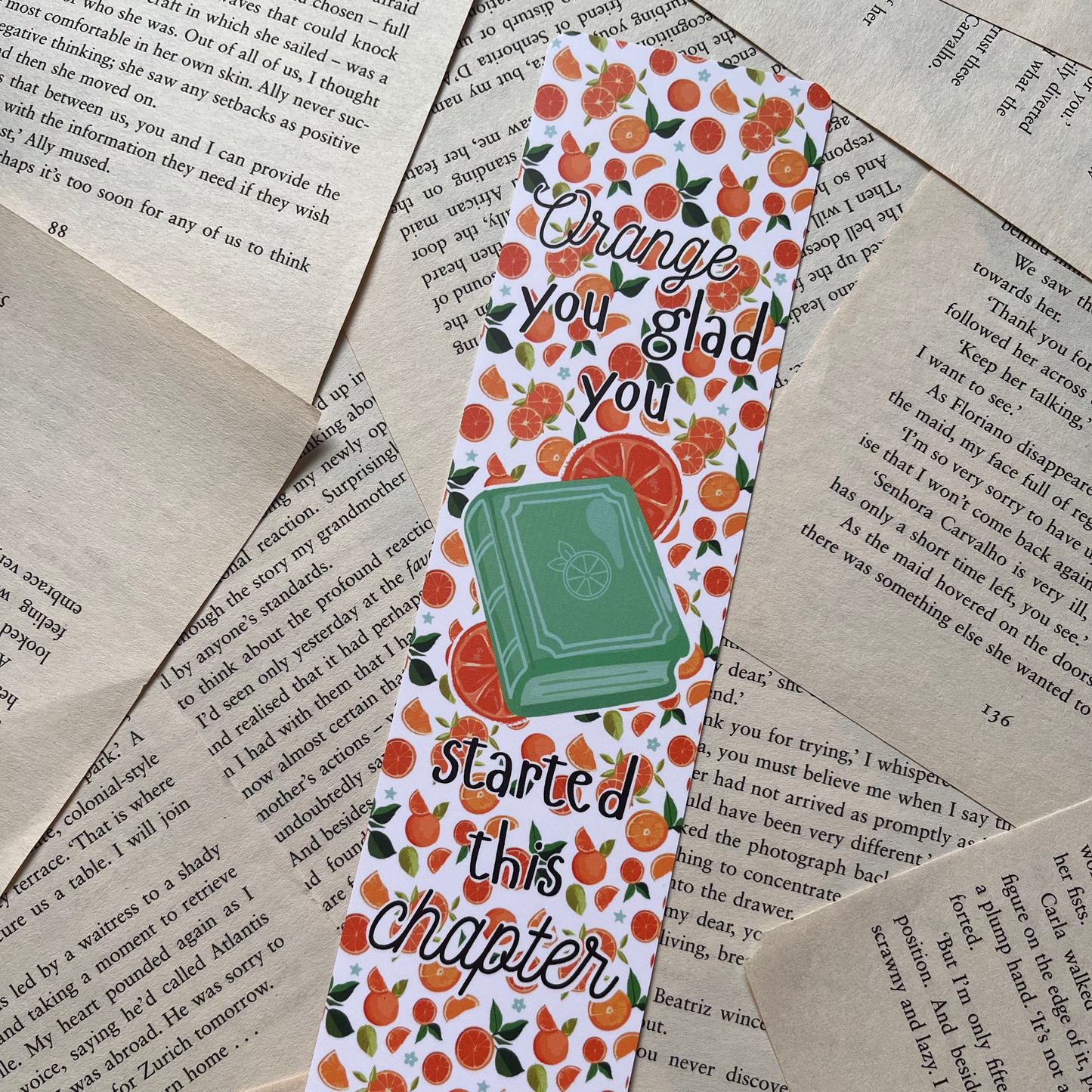 Bookmark with orange design and text on a textured paper background