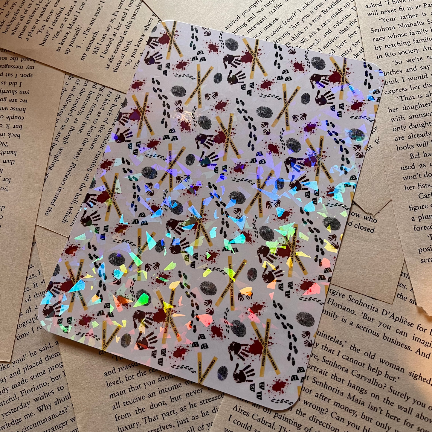 Holographic kindle insert with a thriller themed pattern placed on decorative book pages