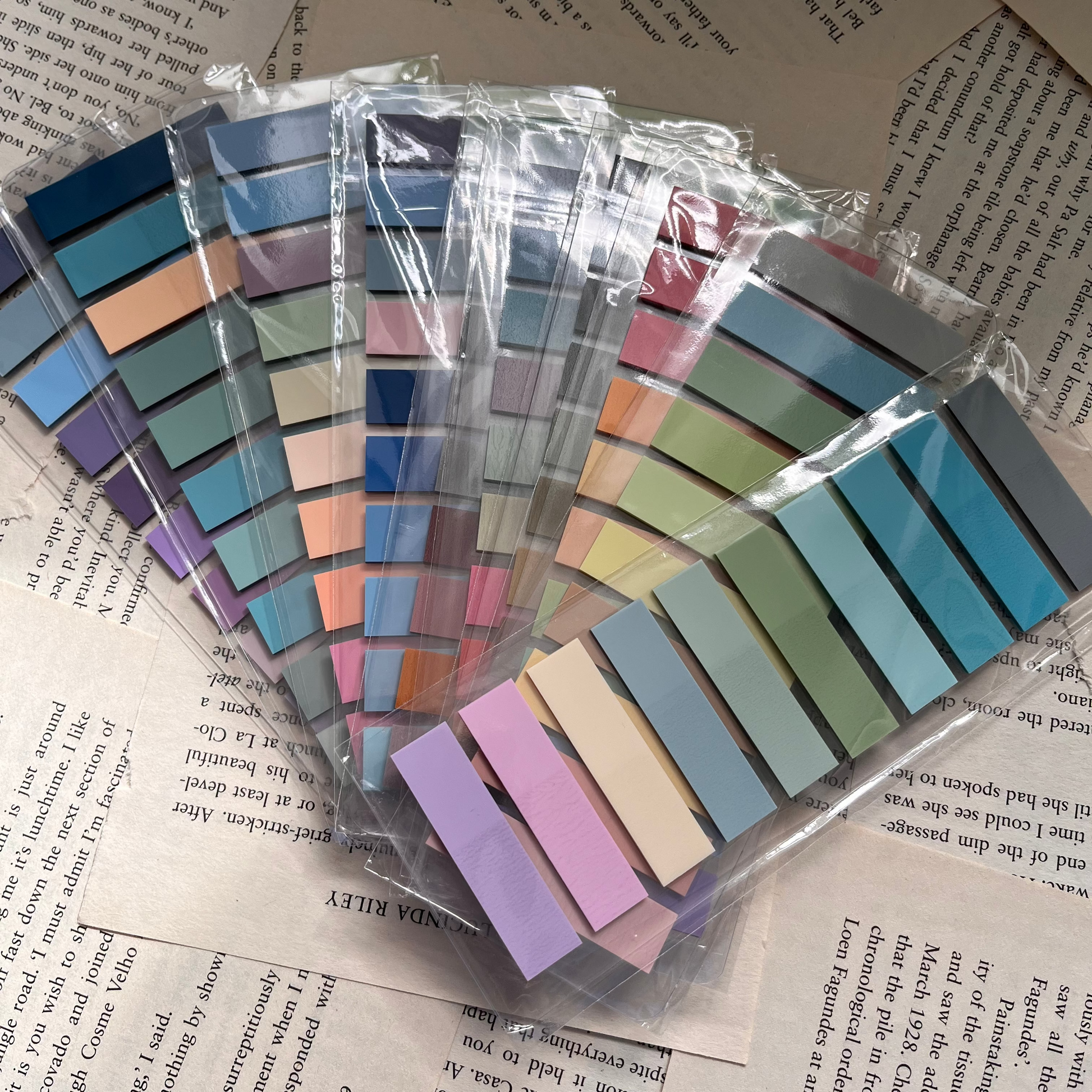 Photo shows a range of colourful book tabs in clear plastic placed on book pages