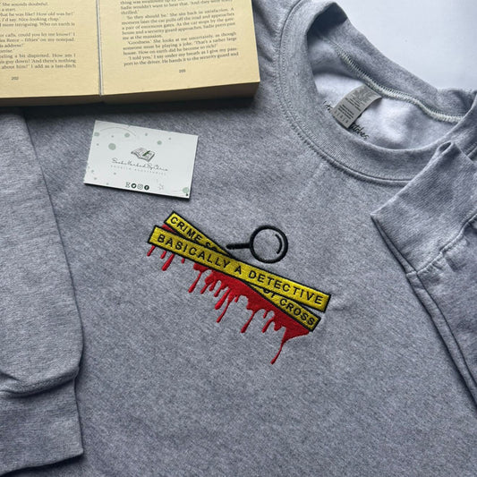 Gray sweatshirt with a detective-themed graphic on a light gray background