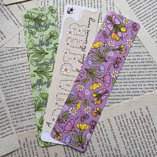 3 colourful spring vibe bookmarks lay on book pages background