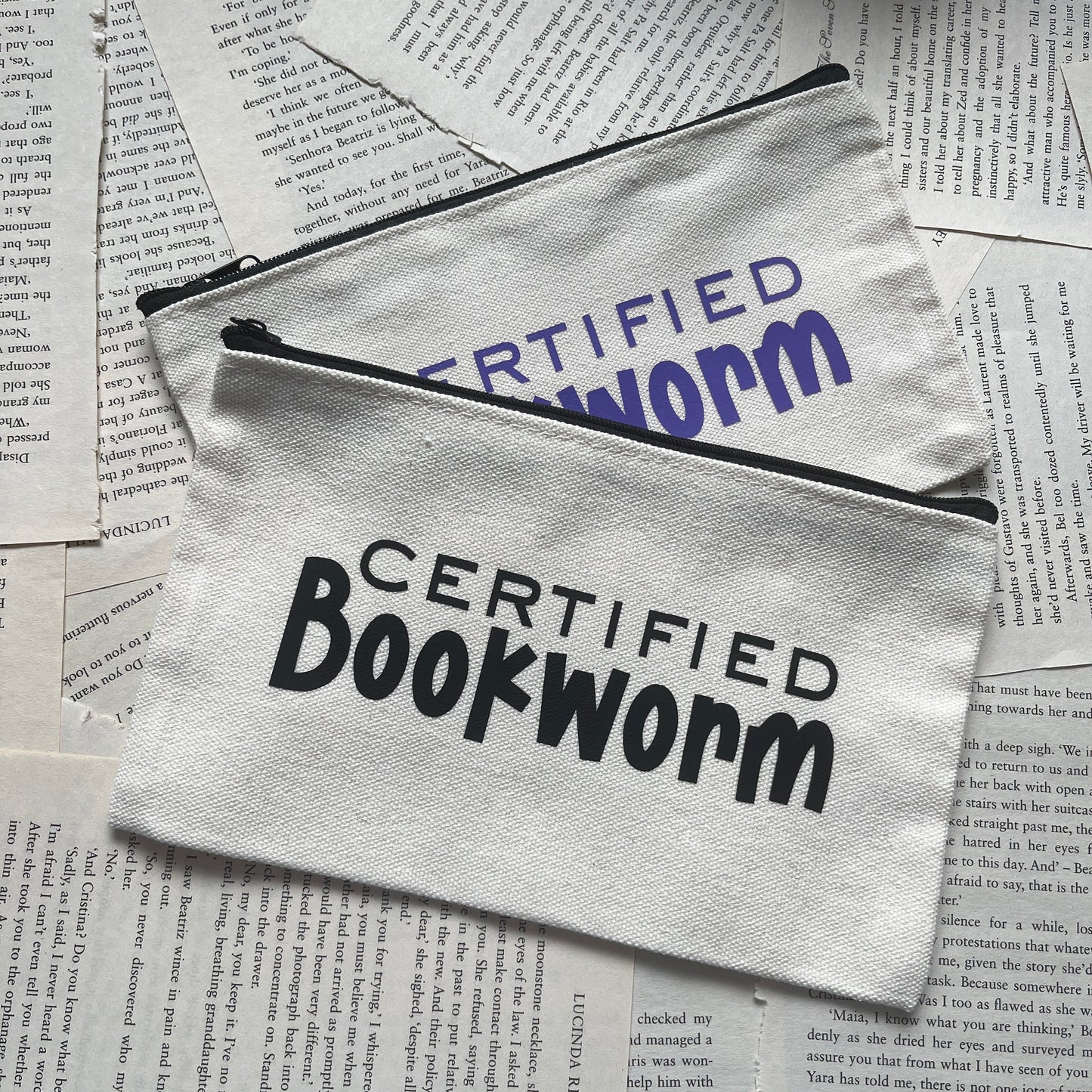 Two zipperpouches labeled 'Certified Bookworm' on top of books.