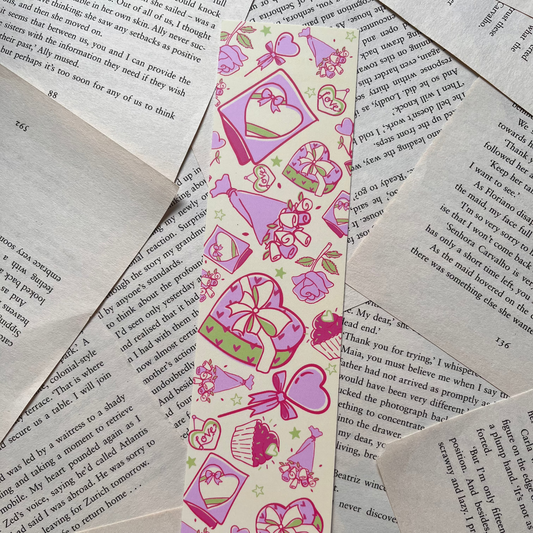 Decorative bookmark with pink and purple designs on a pile of books