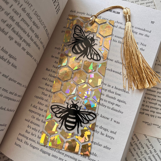Bookmarks with bee designs and tassels on an open book