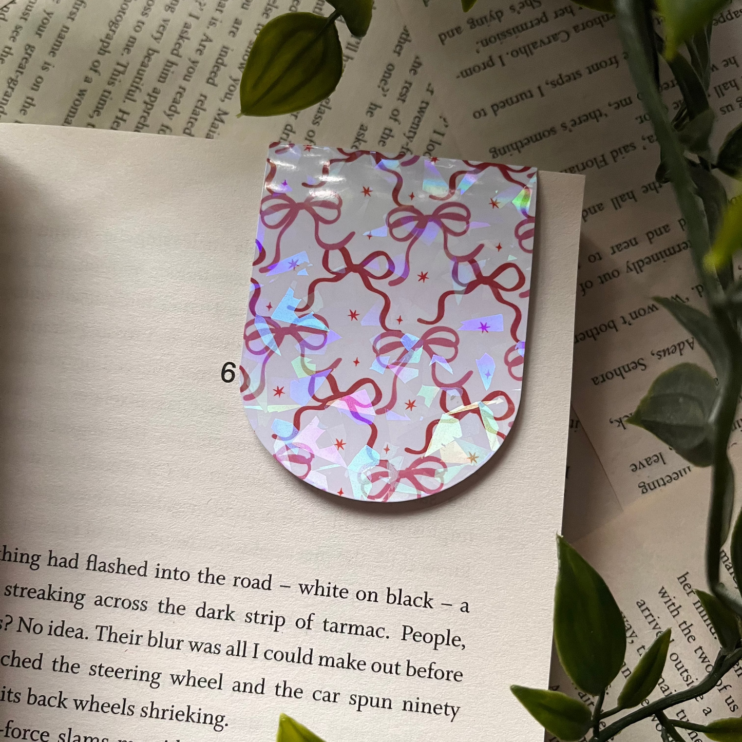 Holographic bookmark on a book with green leaves around