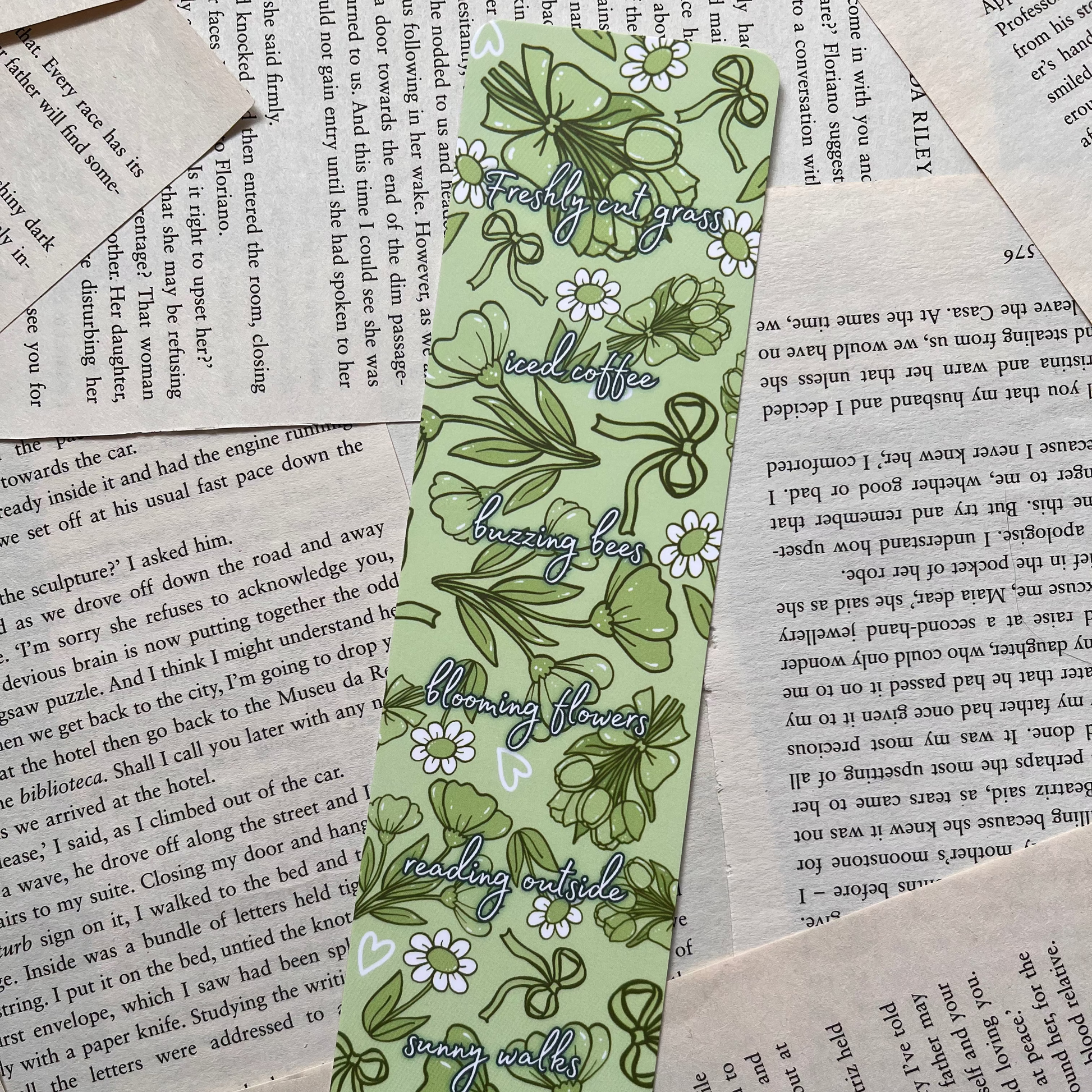 green bookmark with flowers design on book pages background