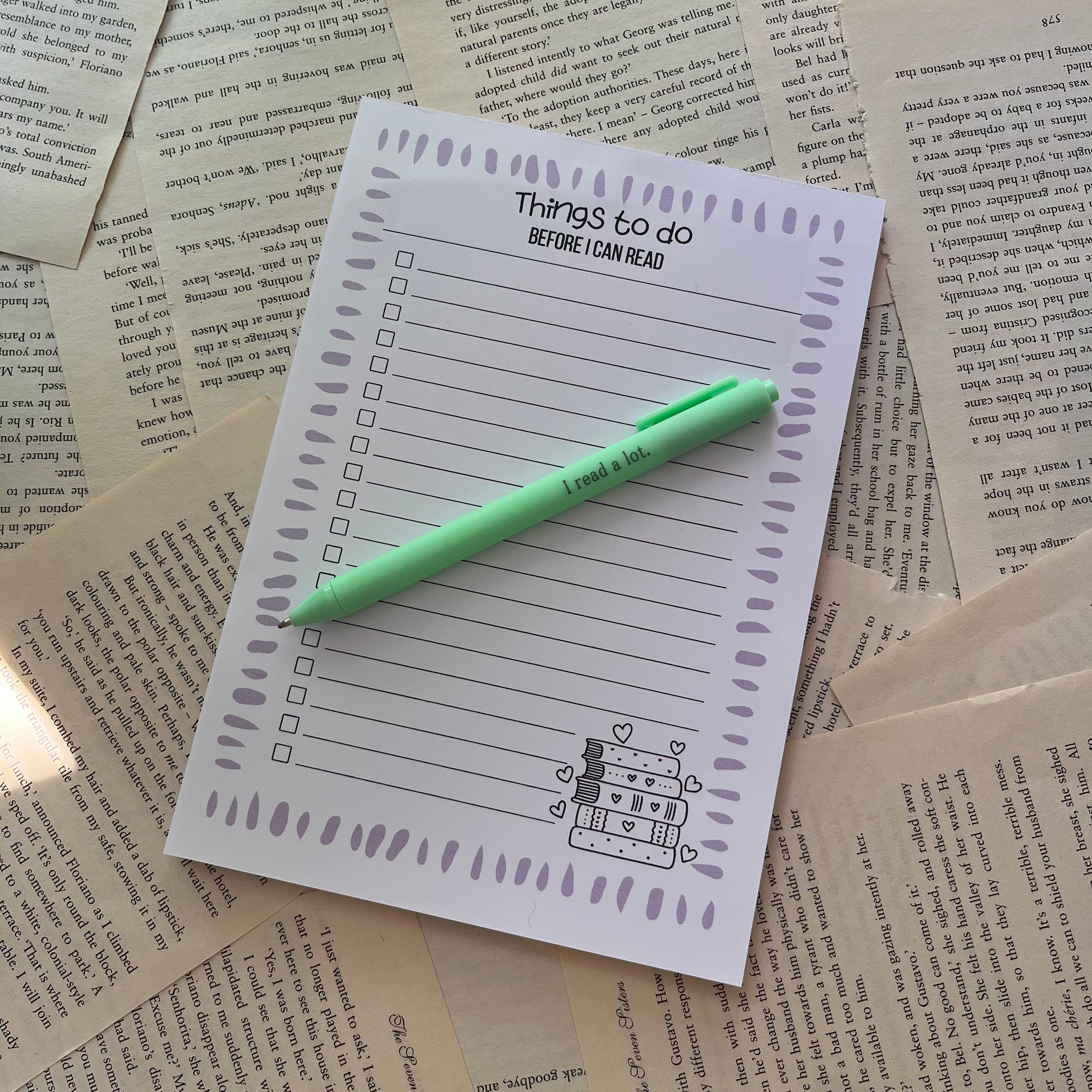 handmade to do list notepad laying on bookpages with a green pen