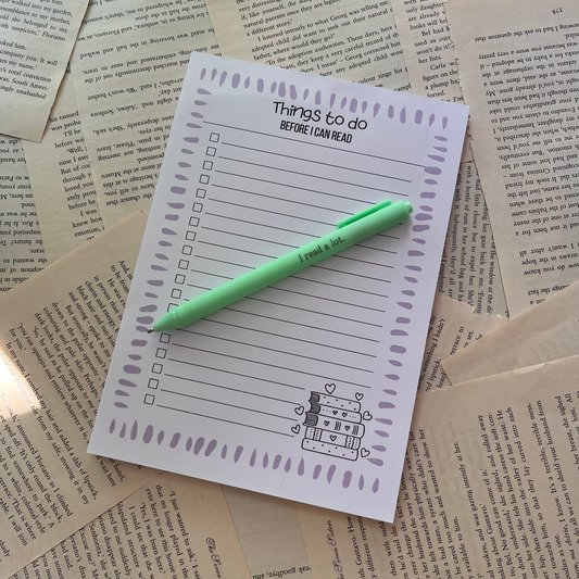 handmade to do list notepad laying on bookpages with a green pen